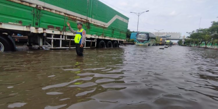 Tidak Hanya Lakukan Pengalihan Arus Lalin, Polrestabes Semarang Bantu Warga Lintasi Genangan Air Kaligawe-Genuk