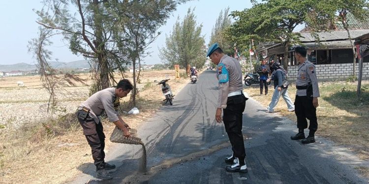 Gerak Cepat Anggota Polsek Lasem Bersihkan Tumpahan Oli di Jalan Desa Dasun
